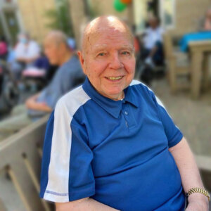 happy older gentleman sitting on outdoor bench